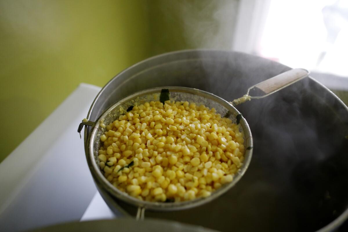 Andres Santos cooks white Mexican corn at his apartment in Los Angeles