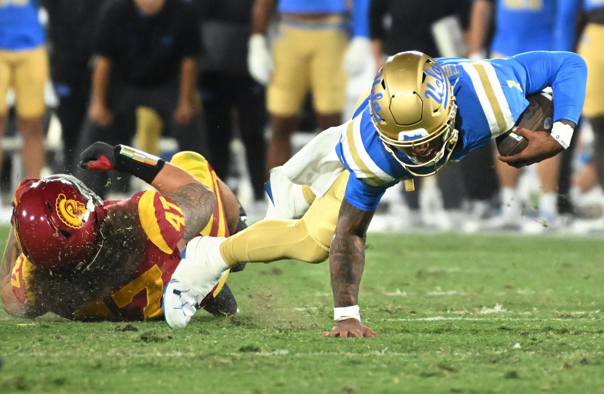 UCLA quarterback Dorian Thompson-Robinson is tackled by USC's Tuli Tuipulotu.