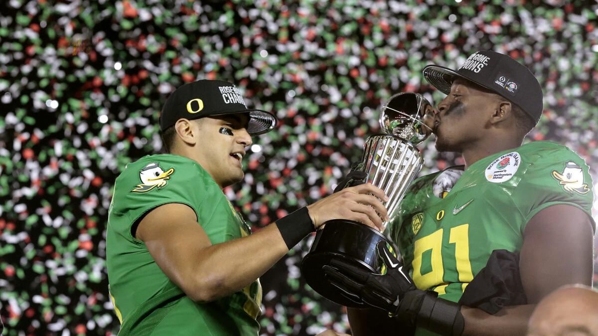 Oregon quarterback Marcus Mariota, left, and linebacker Tony Washington celebrate the Ducks' victory over Florida State in the College Football Playoff semifinal at the Rose Bowl on Jan. 1.