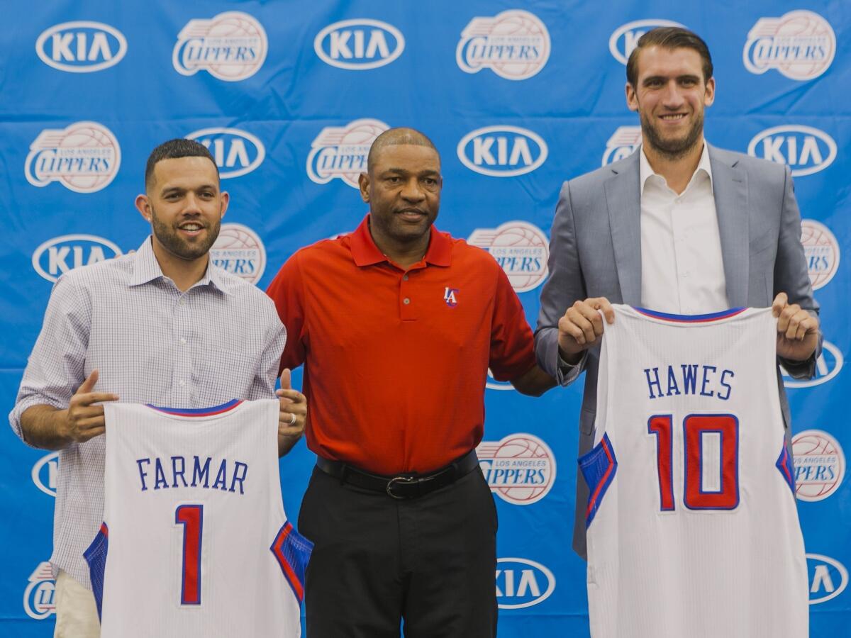 Clippers Coach Doc Rivers, center, stands with his team's two newest members, former Lakers guard Jordan Farmar, left, and big man Spencer Hawes, right, who last played for Cleveland.
