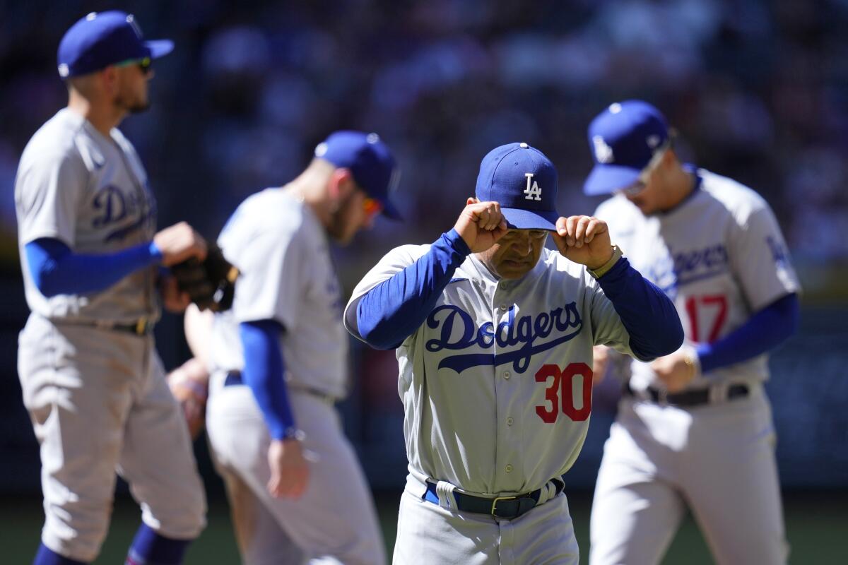 Dodgers manager Dave Roberts walks off the field after pulling starting pitcher Michael Grove.