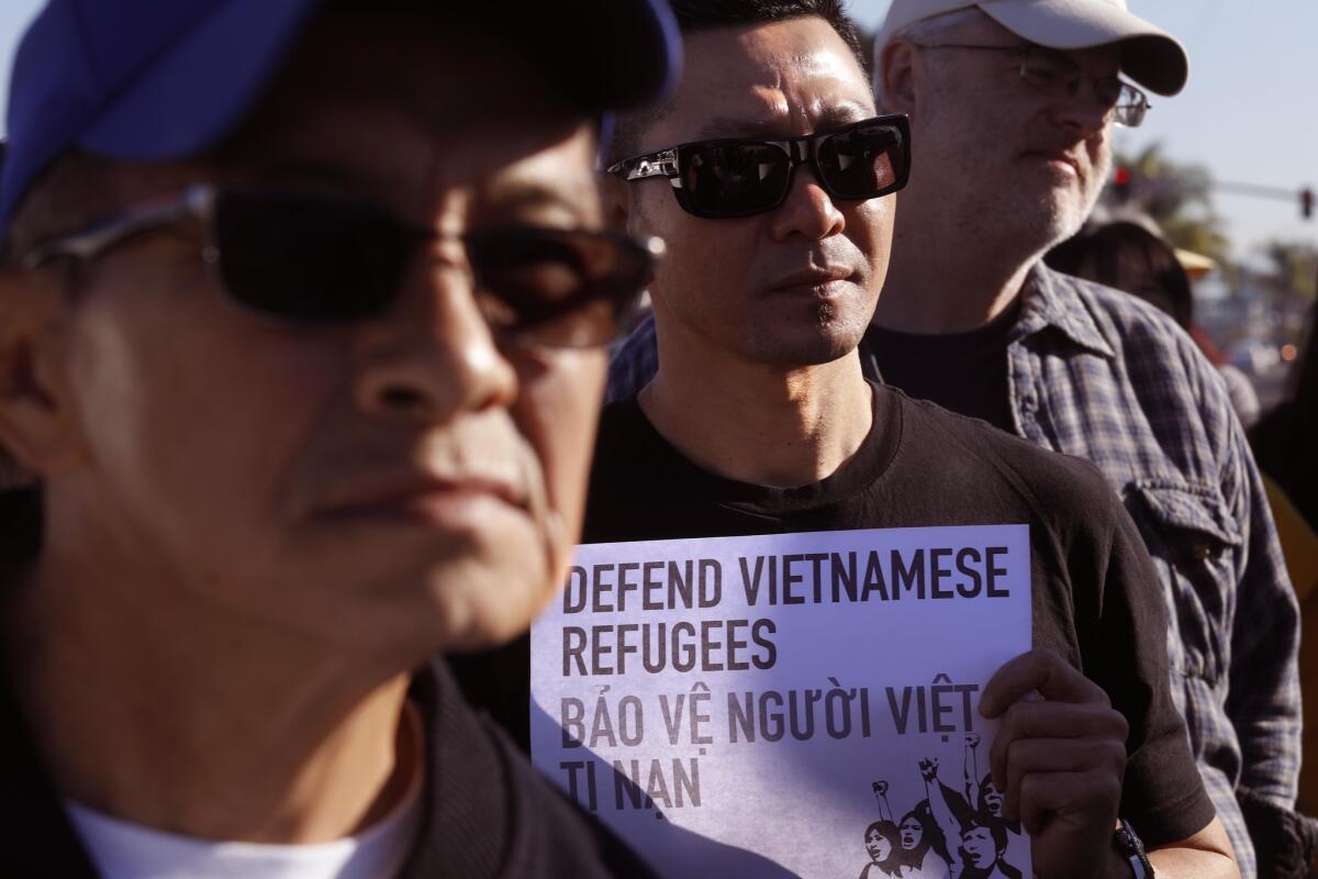 Hoang Ly, center, joins members of the Little Saigon community, who marched against a Trump Administration's policy shift that puts 8,500 Vietnamese community members at risk of deportation.