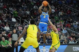 UCLA guard Dylan Andrews (2) shoots over Oregon center N'Faly Dante (1) and guard Jackson Shelstad.