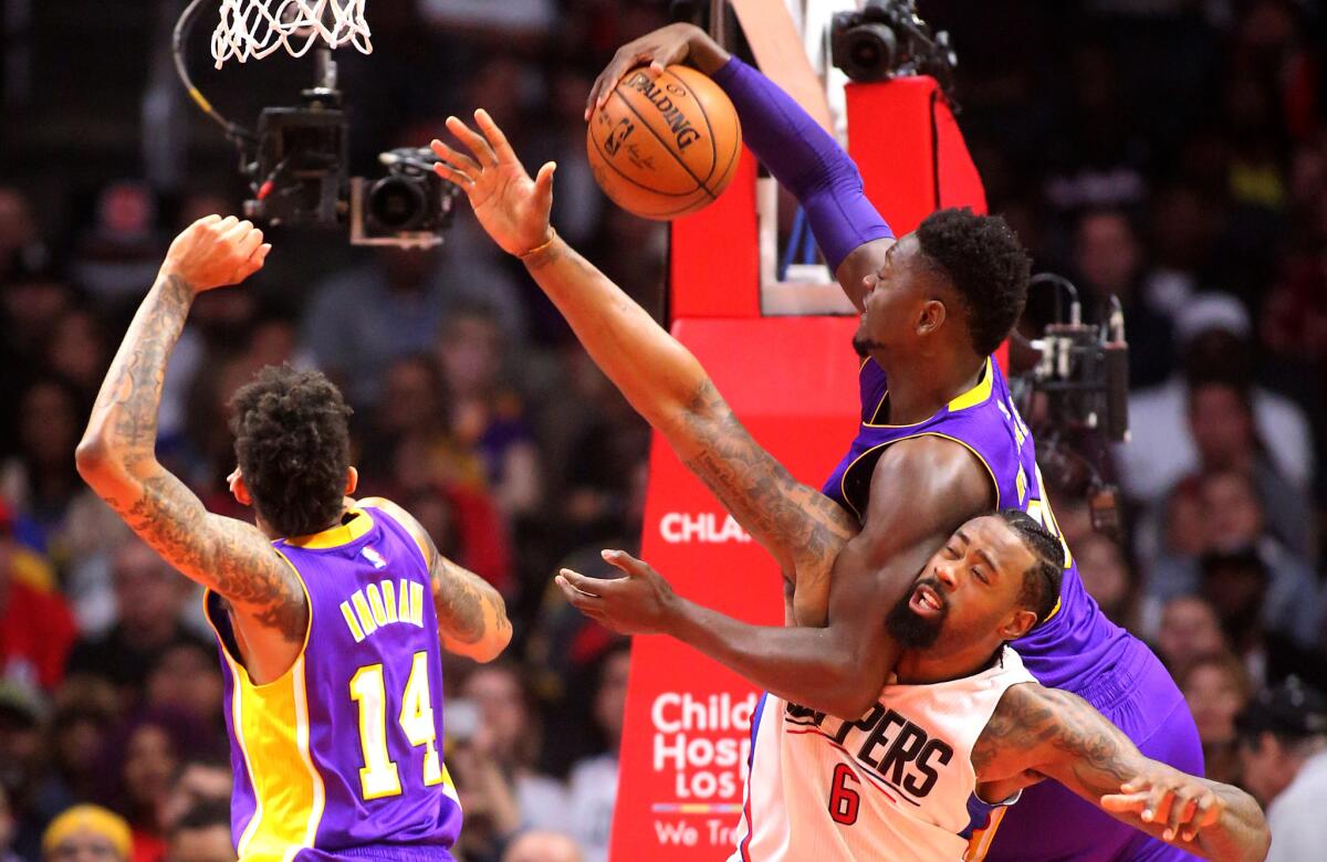 Lakers forward Julius Randle gets tangled up with Clippers center DeAndre Jordan as they battle for a rebound during the first half on Jan. 14.