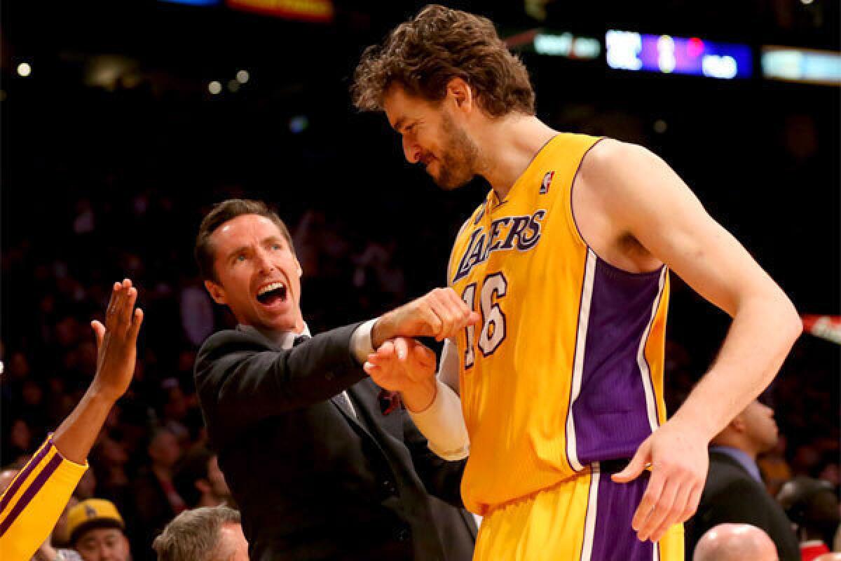 Pau Gasol is greeted by injured teammate Steve Nash in the closing seconds of the Lakers' overtime victory over Houston.
