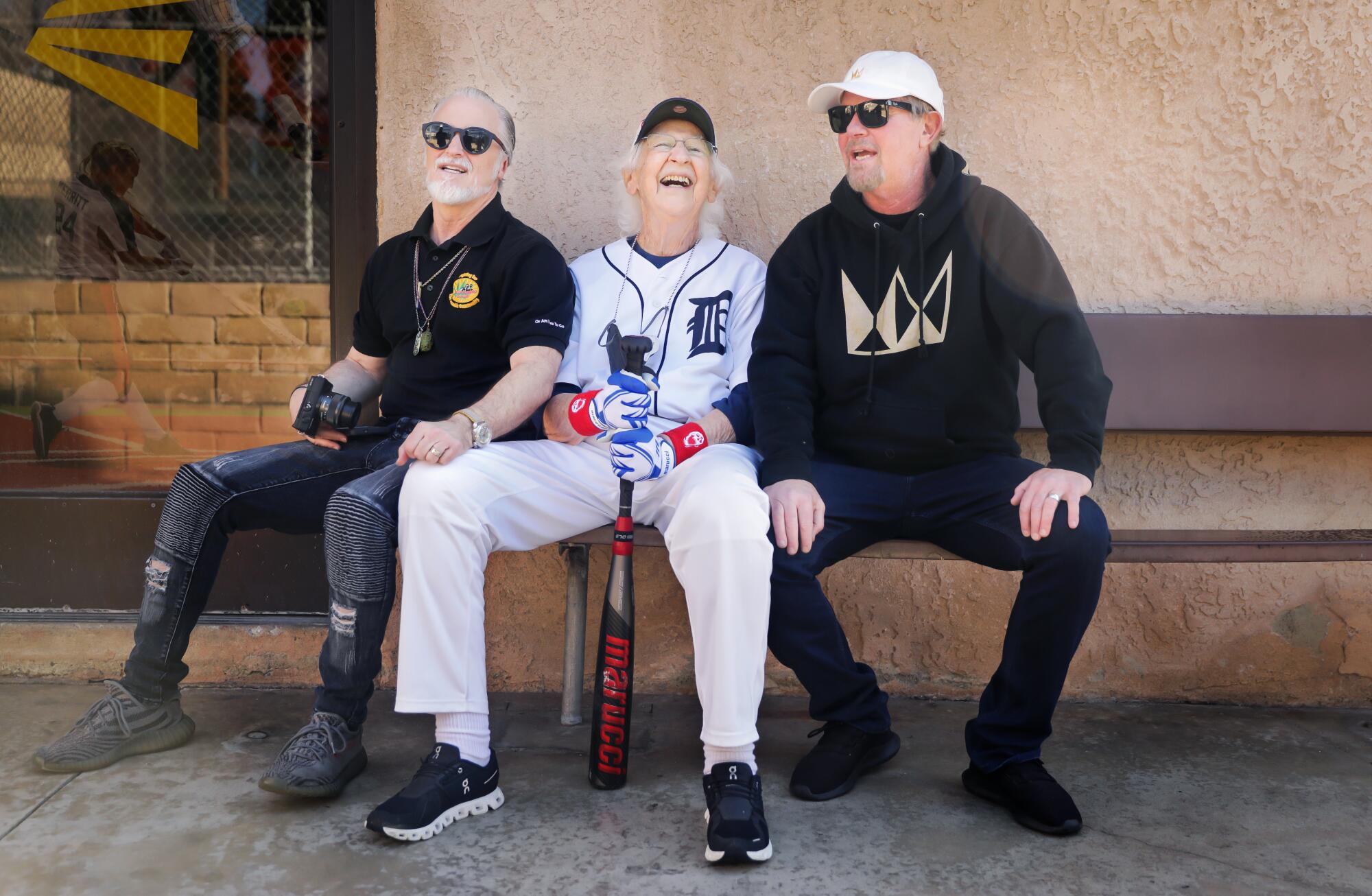 Three men take a break between hitting balls at the batting cages in Anaheim.
