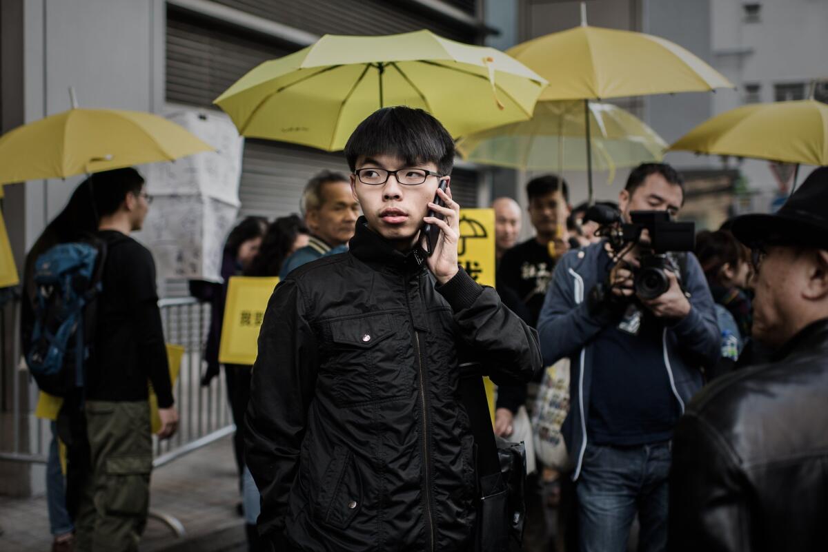 Student activist Joshua Wong talks on the phone after walking out of the Wanchai police station in Hong Kong on Jan. 16.