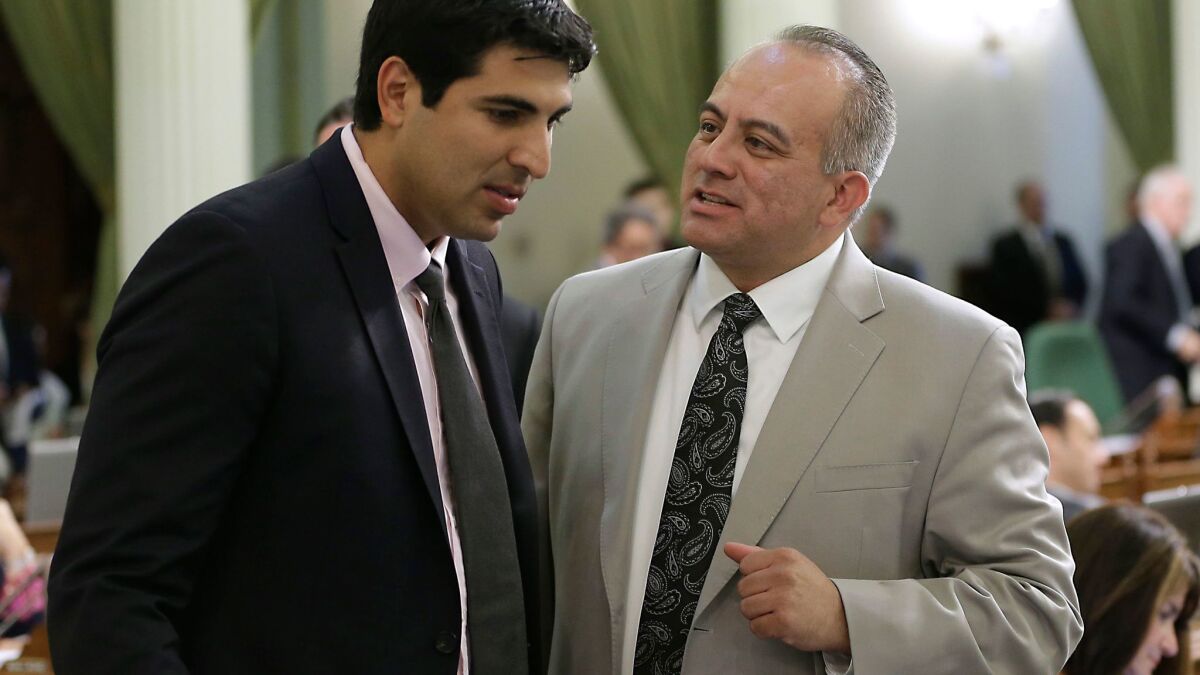 Former Assemblyman Raul Bocanegra (D-Pacoima), right, discusses a bill with Assemblyman Matt Dababneh (D-Woodland Hills) at the Capitol in Sacramento in 2014. Both men have decided to resign while facing allegations of sexual harassment.