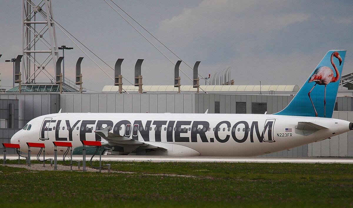A Frontier Airlines plane taxis the runway at Cleveland Hopkins Airport.