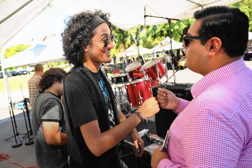 Maywood Music Festival organizer Jonathan Jimenez, left, thanks a member of the group Whiskey Dynamos after the concert.