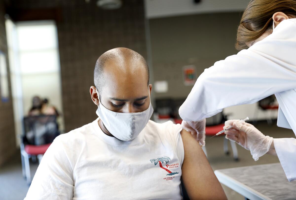 Wesley Campbell receives a shot by a pharmacist.