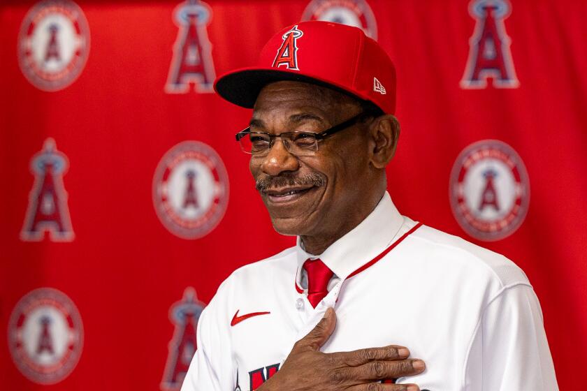 Angels new manager Ron Washington places his hand over his heart as he shows off his new Angels jersey.