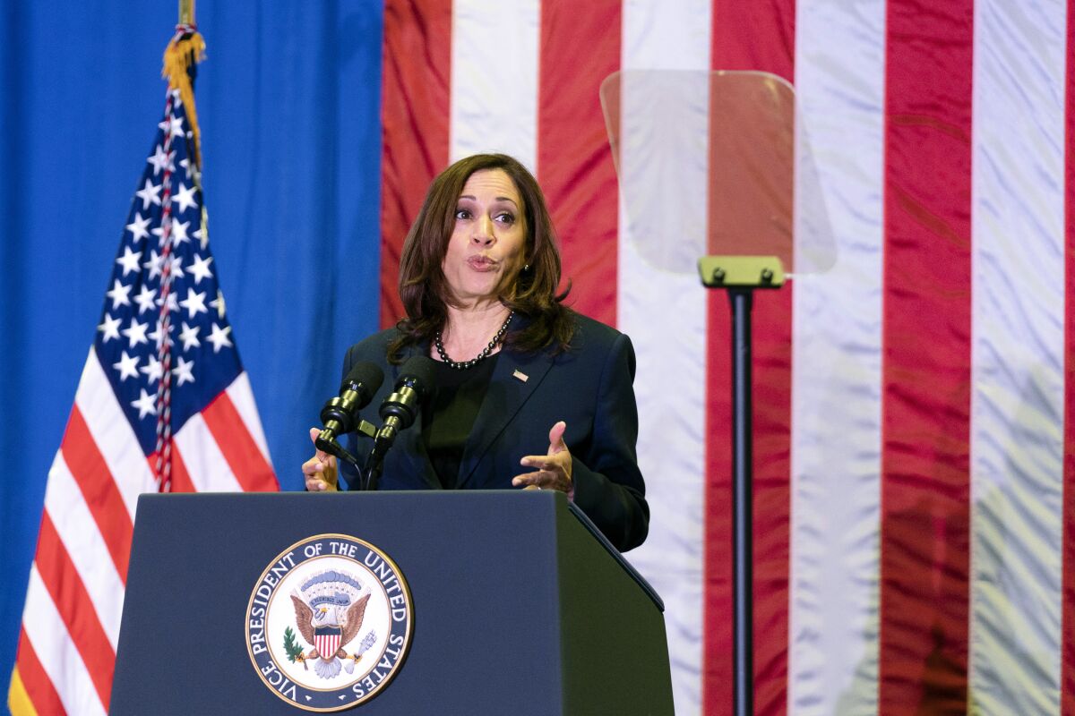Vice President Kamala Harris speaks at a podium with American flags behind her.