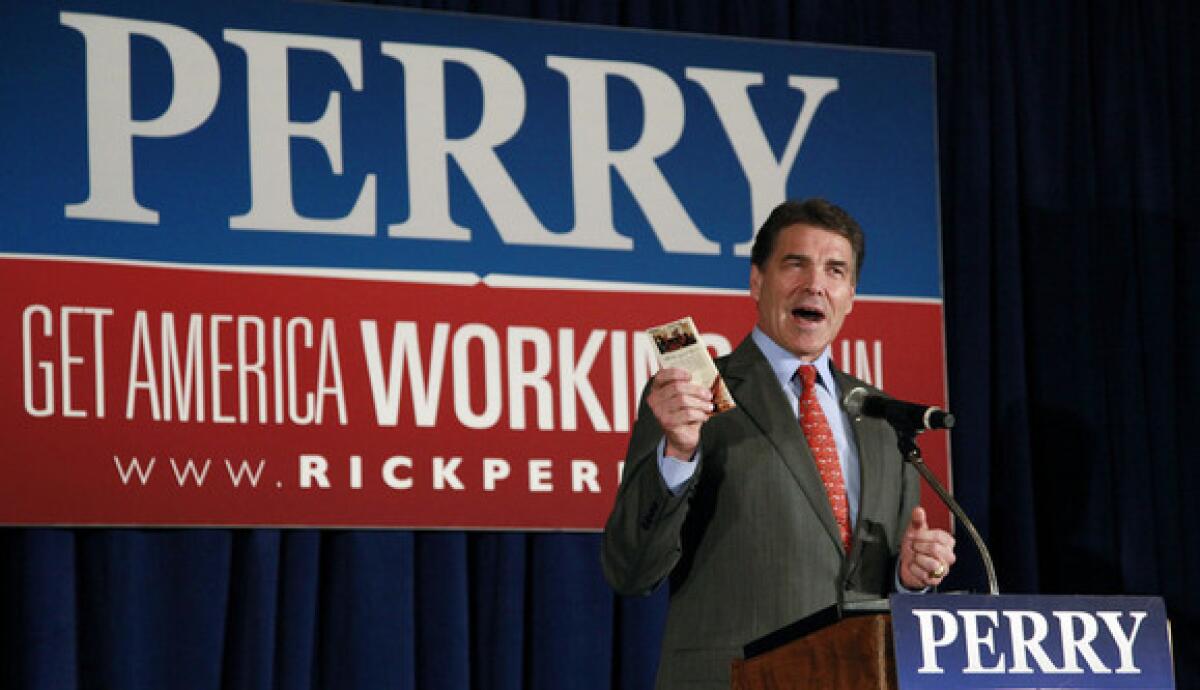 Texas Gov. Rick Perry holds up a copy of the U.S. Constitution as he speaks at a campaign town hall in Derry, N.H., on Tuesday.