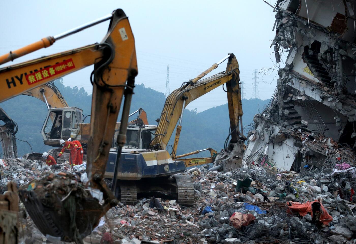 Rescuers search for potential survivors on Dec. 22, 2015, near a damaged buildings after a landslide at an industrial park in Shenzhen, China.