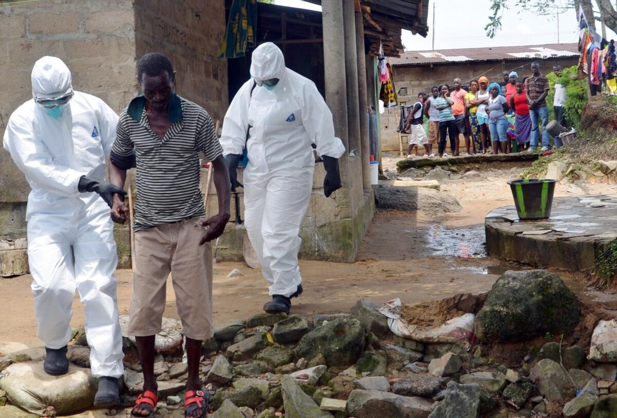 Nurses escort a man infected with the Ebola virus to a hospital in Monrovia, Liberia, on Monday.