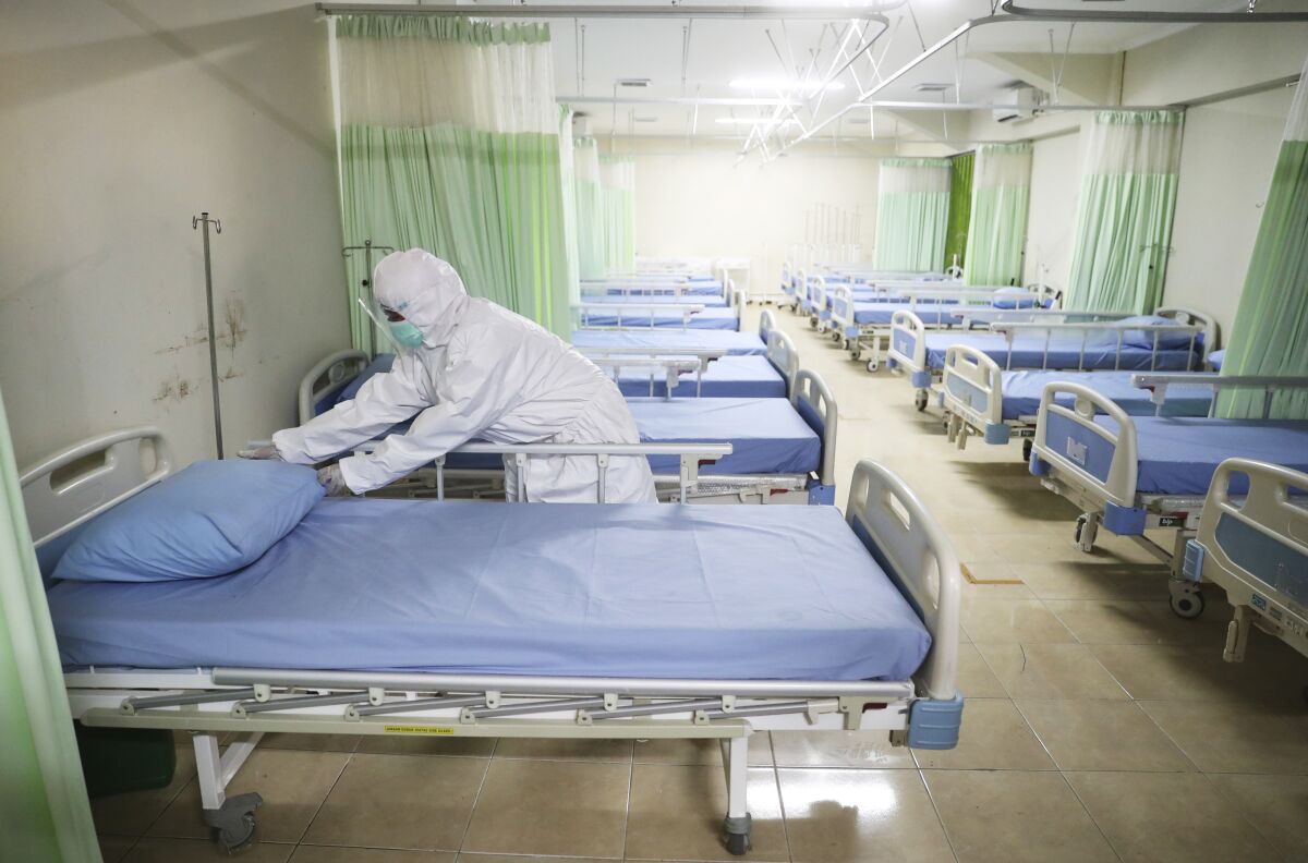 A medics inspects makeshift isolation rooms at Patriot Candrabhaga stadium prepared to become a quarantine facility for people showing symptoms of the COVID-19 amid the new coronavirus outbreak in Bekasi on the outskirts of Jakarta, Indonesia, Wednesday, Sept. 9, 2020. While Indonesia has recorded more deaths from the coronavirus than any other Southeast Asian country, it also has seen by far the most fatalities among medical workers in the region, leading to concerns about the long-term impact on the nation's fragile healthcare system. (AP Photo/Achmad Ibrahim)