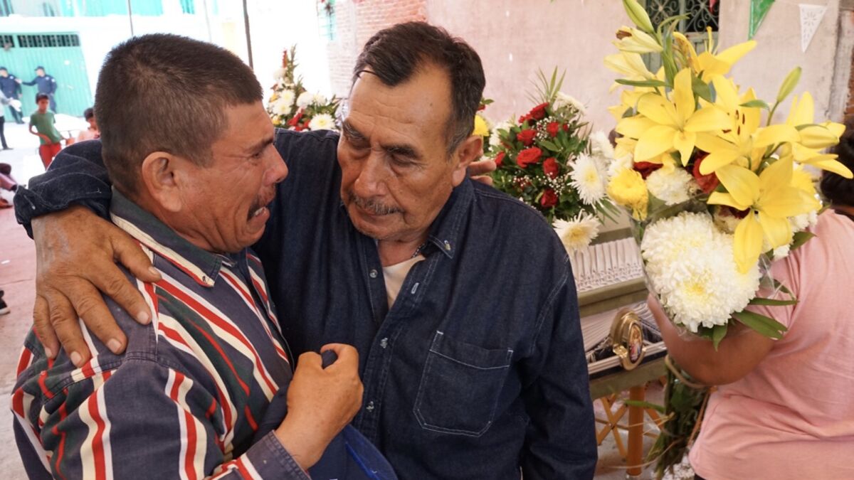 A close relative embraces Graciano Villanueva Perez, 73, who lost his wife, sister, daughter, son-in-law and two grandchildren.