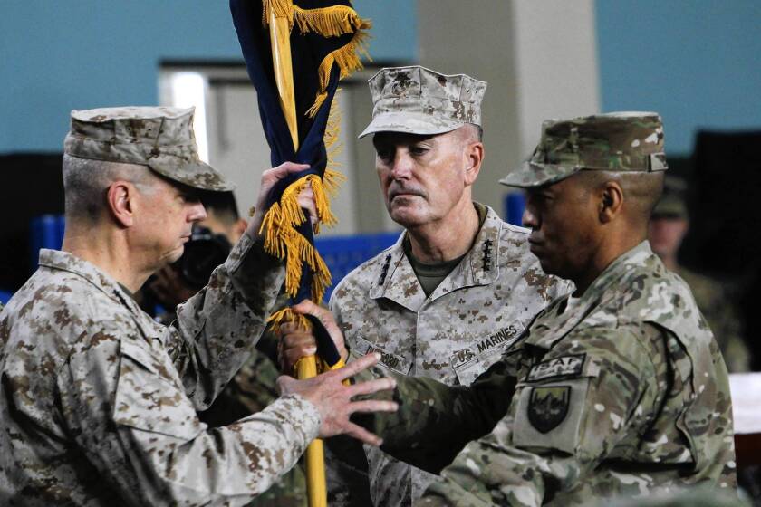 Gen. John R. Allen, left, hands a flag to Gen. Joseph F. Dunford Jr. during a ceremony in Kabul, at which Dunford took over command of the U.S.-led NATO force in Afghanistan.