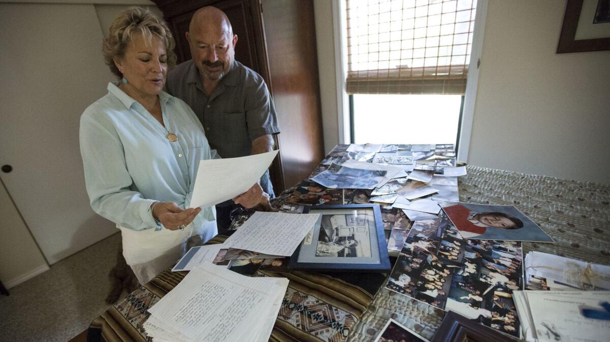 Sharon Holland, left, and husband Carty look over photos and letters written by their son Andrew Holland.