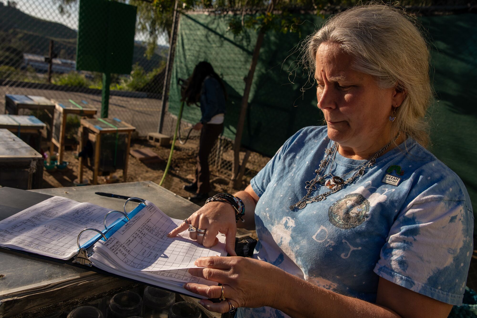 Jana Johnson peers at a spiral-bound folder.