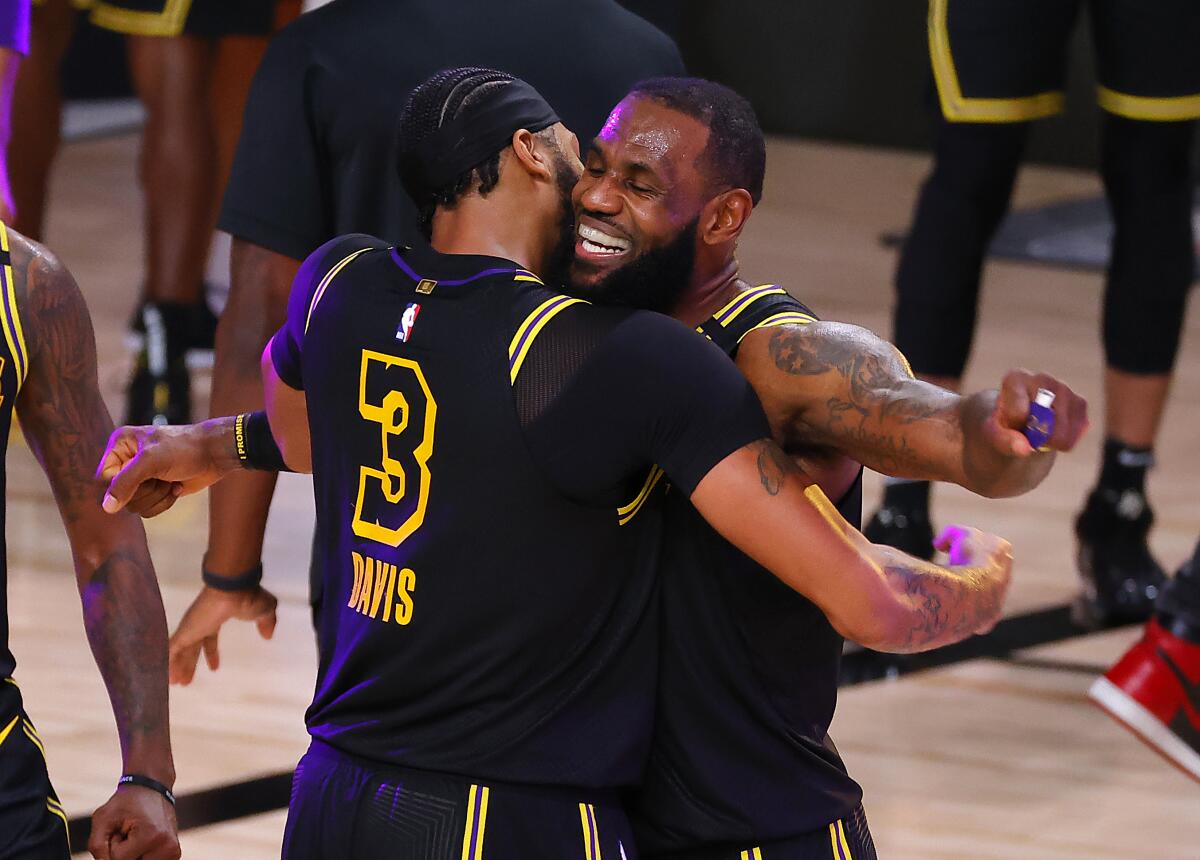 LeBron James, right, celebrates with Anthony Davis, who shot a three-point basket to beat the Denver Nuggets.