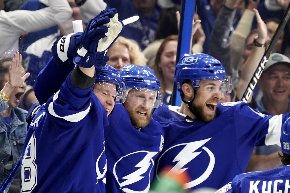 Tampa Bay Lightning center Steven Stamkos, center, celebrates his goal against the New York Rangers with Jan Rutta, right and Tampa Bay Lightning left wing Ondrej Palat, left, during the second period in Game 6 of the NHL hockey Stanley Cup playoffs Eastern Conference finals, Saturday, June 11, 2022, in Tampa, Fla. (AP Photo/Chris O'Meara)