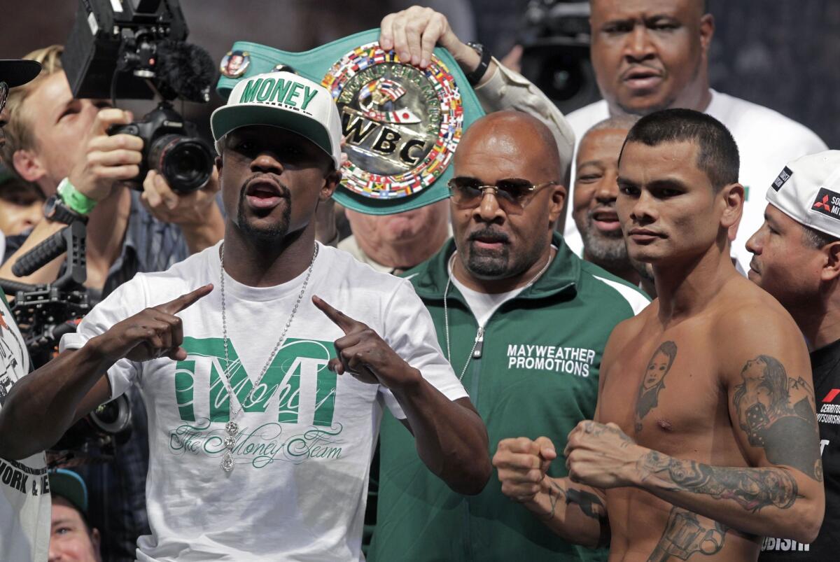Floyd Mayweather Jr., left, and Marcos Maidana pose during their weigh-in Friday.