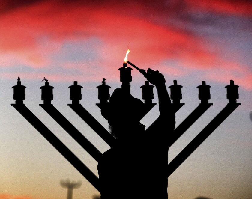 A rabbi lights the menorah on the first night of Hanukkah in Maitland, Fla., on Dec. 10, 2020. 