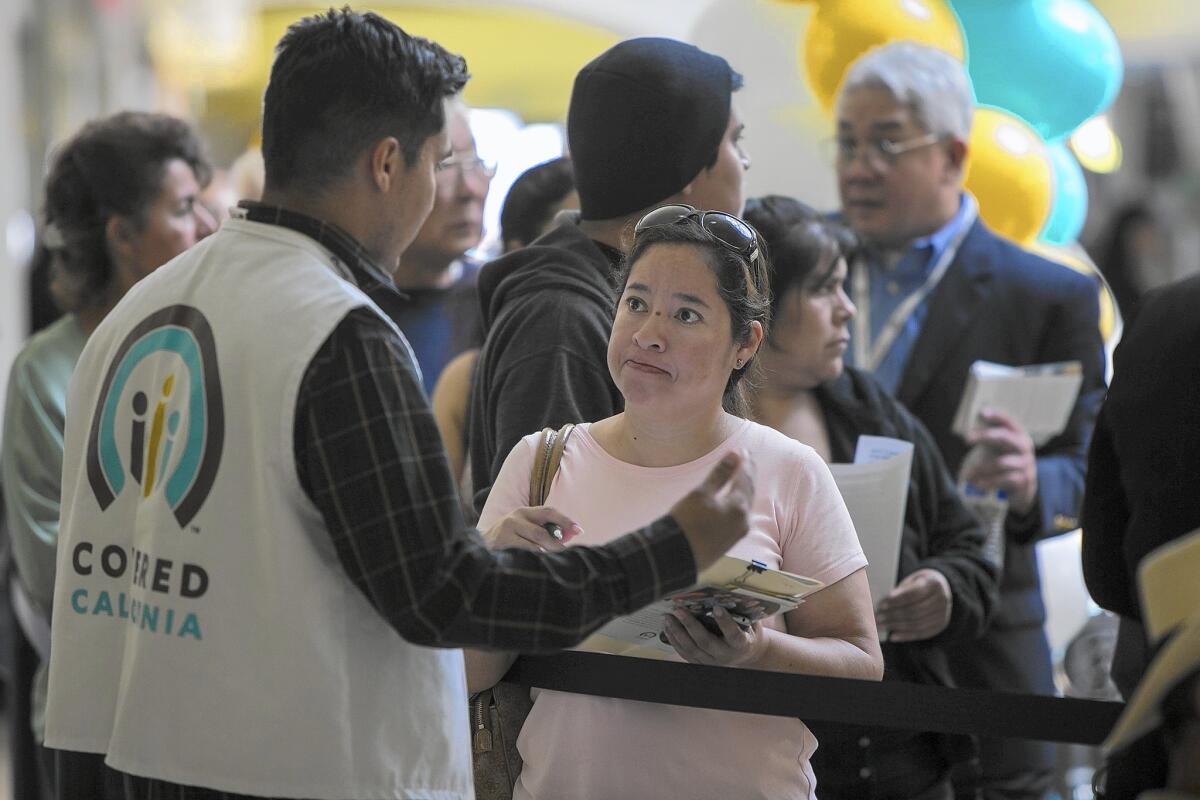 People stand in line at Panorama Mall in Panorama City to enroll in the Covered California health exchange in 2014. The state-run marketplace is embarking on an ambitious effort to collect insurance company data on prescriptions, doctor visits and hospital stays for every Obamacare patient.