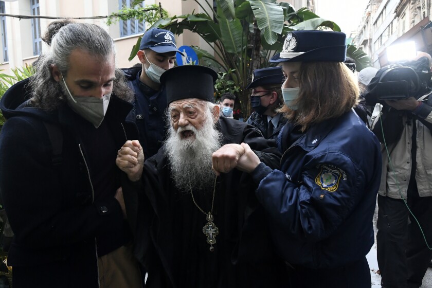 Police hold a protesting Orthodox Priest during the visit of Pope Francis at the Archbishopric of Greece in Athens, Saturday, Dec. 4, 2021. Pope Francis warned Saturday that the "easy answers" of populism and authoritarianism threaten democracy in Europe and called for fresh dedication to promoting the common good. (AP Photo/Michael Varaklas)