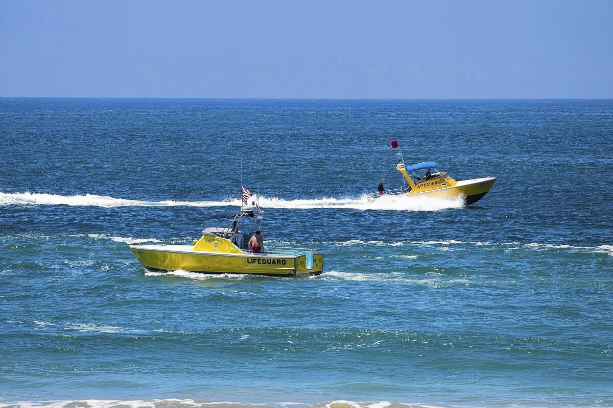 Lifeguard boats patrol the shores on Wednesday in Newport Beach.