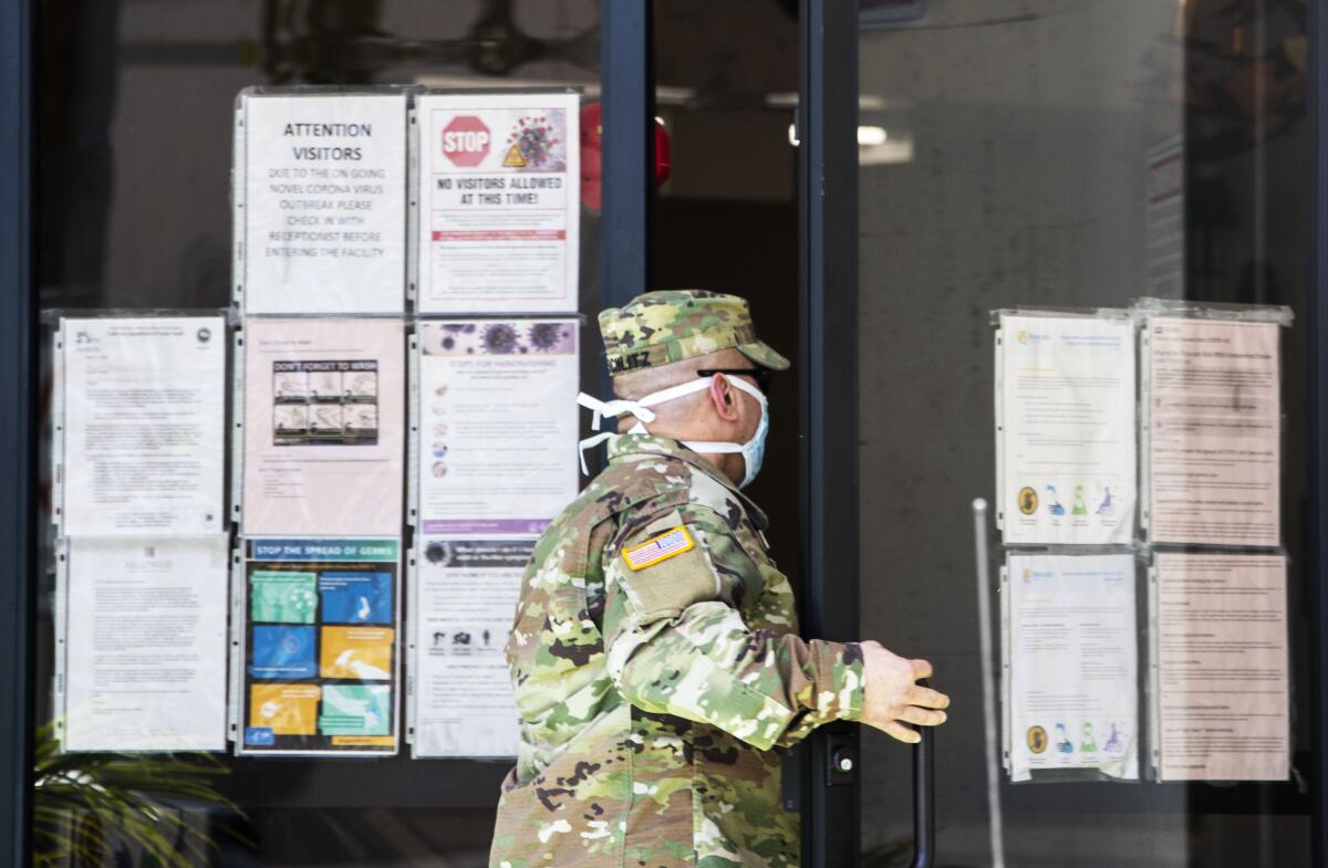 National Guard Sgt. Joseph Schlitz enters the Hollywood Premier Healthcare Center, which has seen 25 coronavirus cases among staff and 29 among residents.