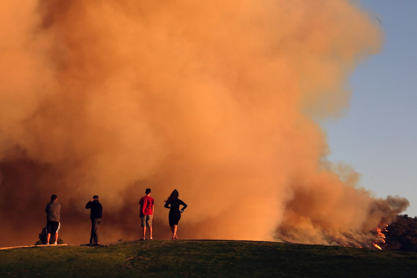 Spectators watch as the Colby fire continues to burn on the edge of the Angeles National Forest in January.