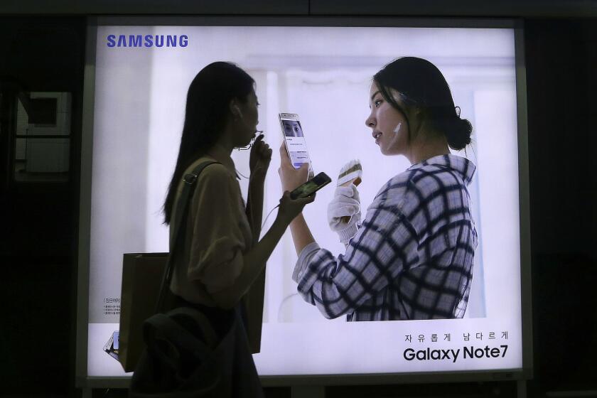 A woman walks by an advertisement for Samsung's Galaxy Note 7 smartphone at a subway station in Seoul in September.