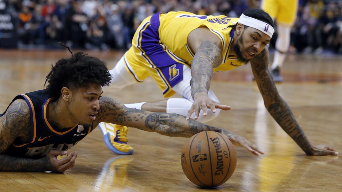 Phoenix Suns forward Kelly Oubre Jr., left, dives for a loose ball in front of Lakers' Brandon Ingram during the first half.
