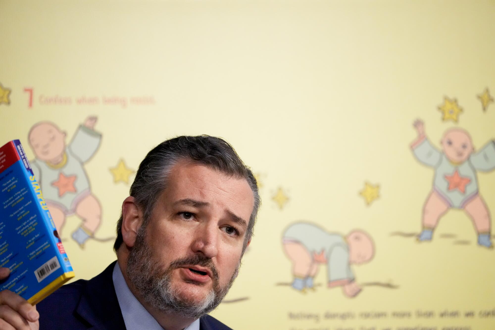 Sen. Ted Cruz holds up a book while speaking. 