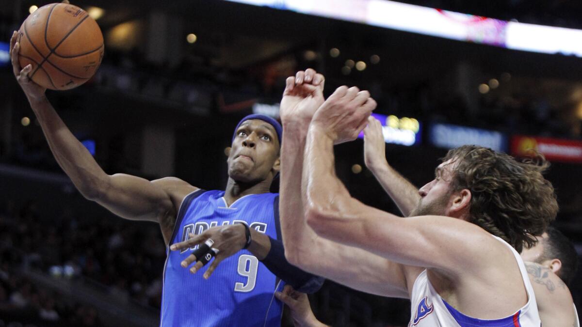 Dallas Mavericks guard Rajon Rondo, left, puts up a shot over Clippers forward Spencer Hawes during the Clippers' 120-100 win at Staples Center on Jan. 10.