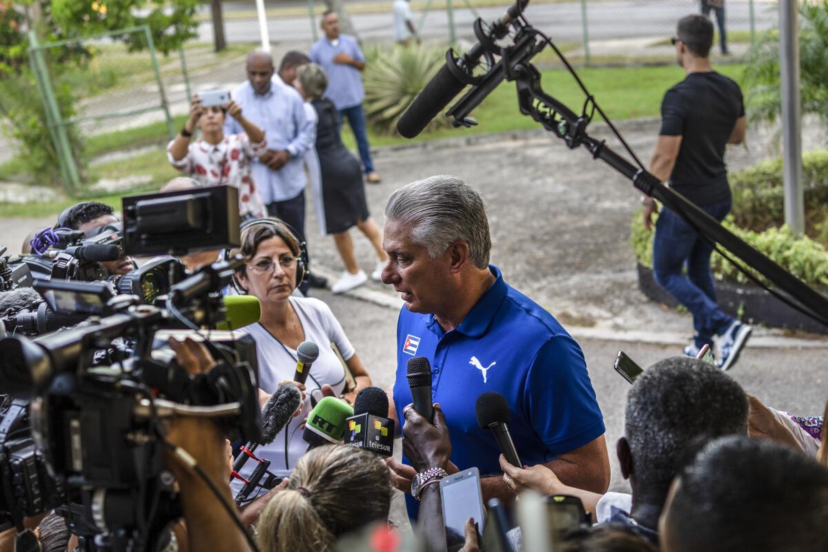 A man stands outdoors, surrounded by reporters with cameras and microphones