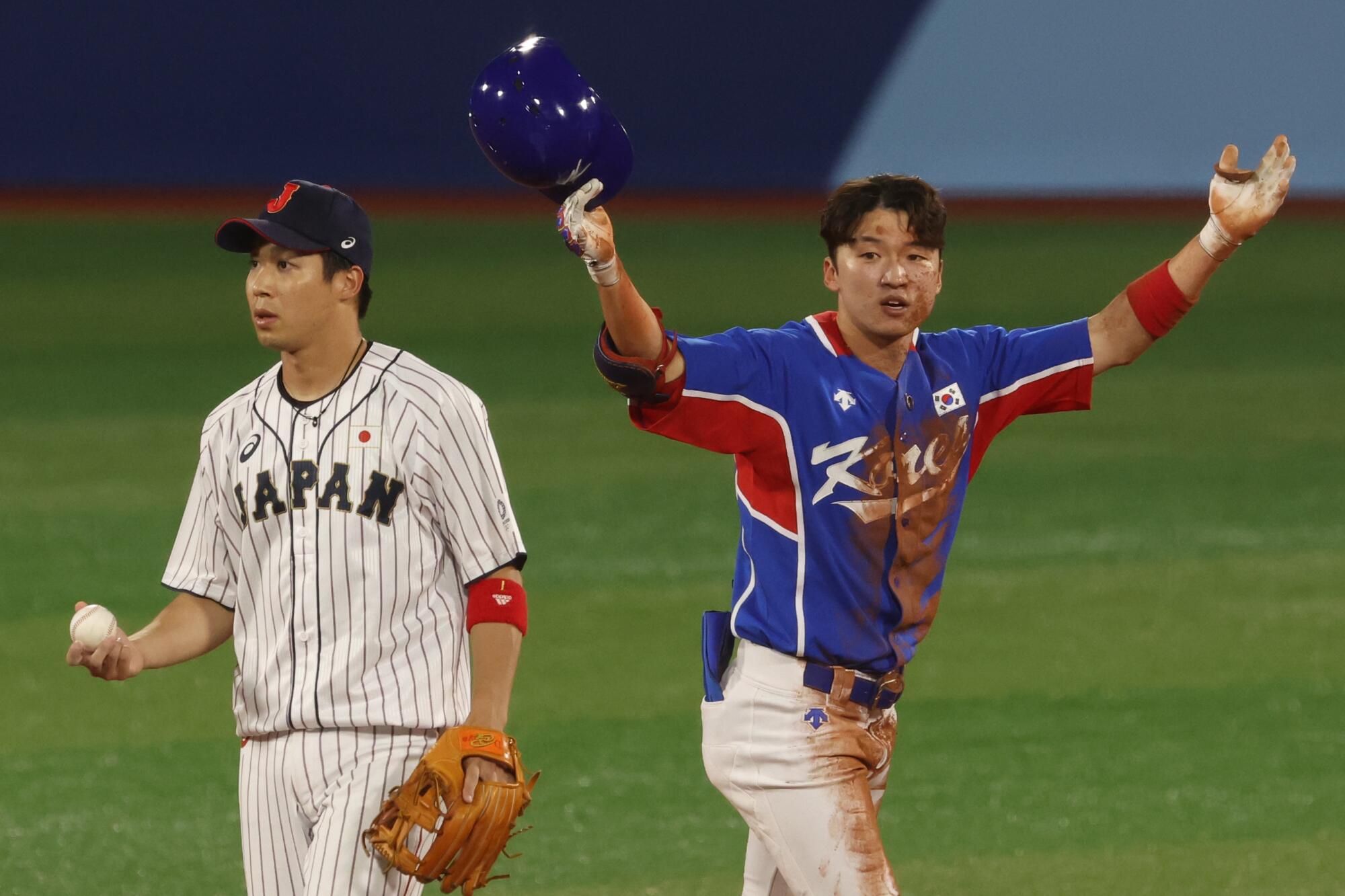 South Korea outfielder Hae Min Park celebrates next to Japan infielder Tetsuto Yamada.