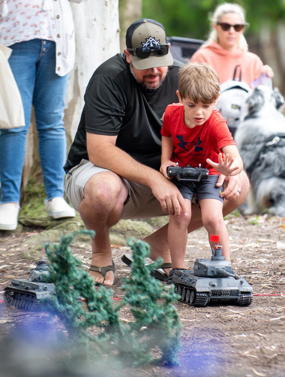 Jake, 4, reaches out to touch a remote-controlled RC tank at Huntington Central Park.