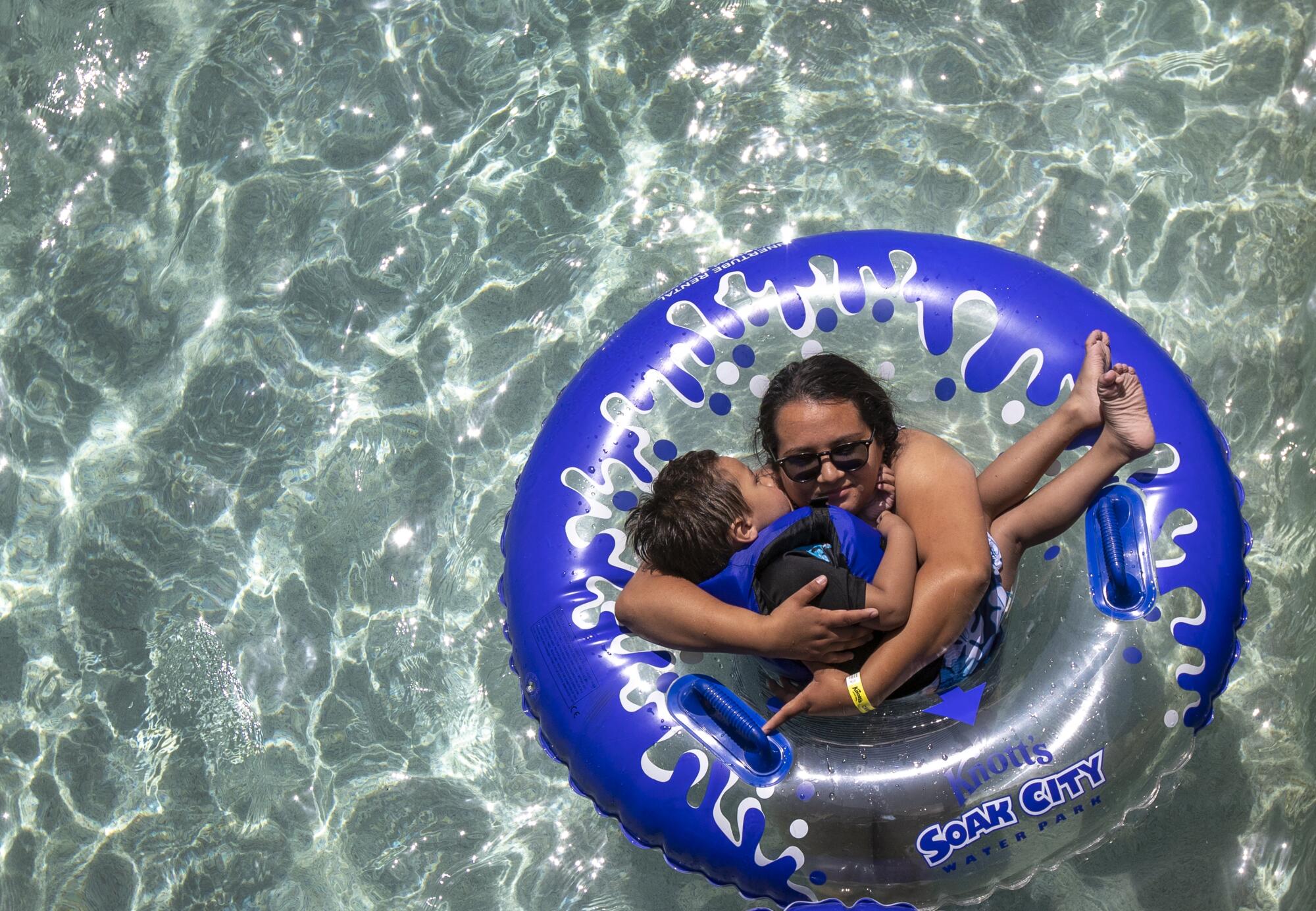 A woman gets a kiss from her child while floating down the Sunset River.