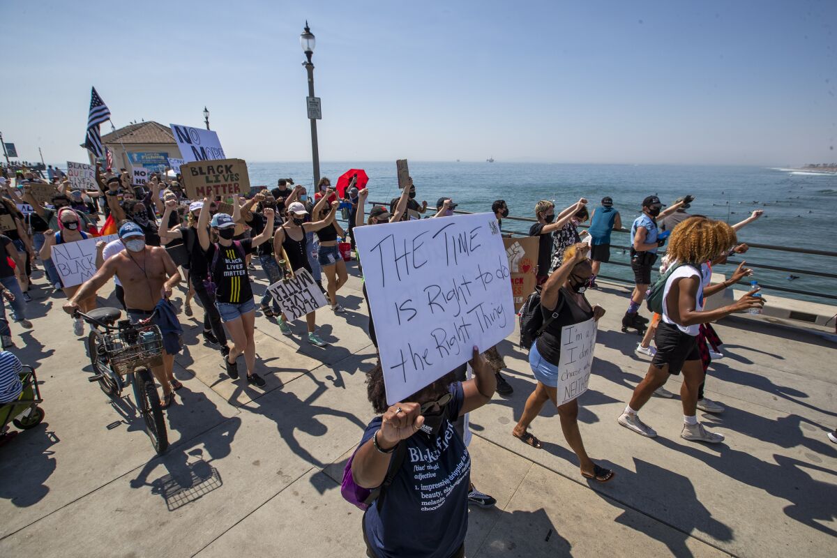  Black Lives Matter protesters march down the Huntington Beach pier in protest of justice for George Floyd. 