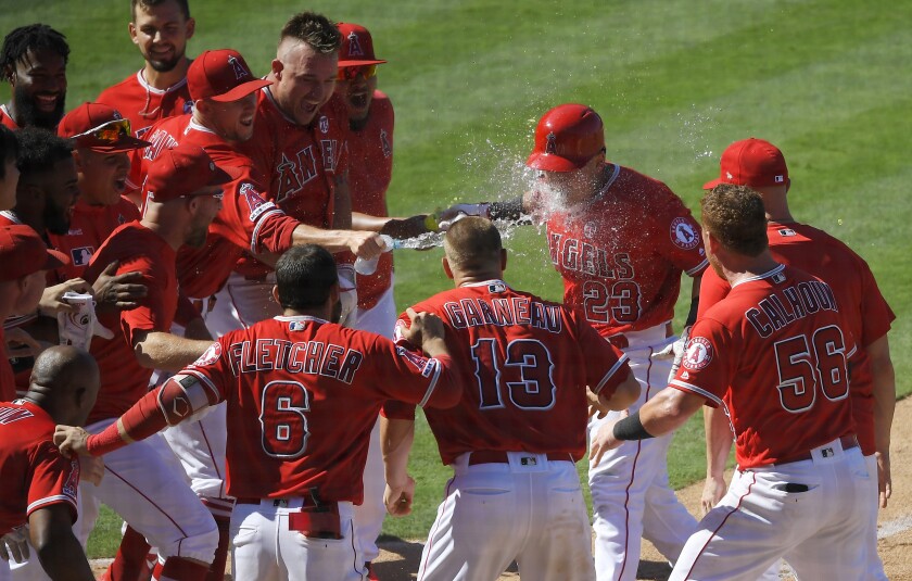 Angels rookie Matt Thaiss is splashed by his teammates while crossing home plate.