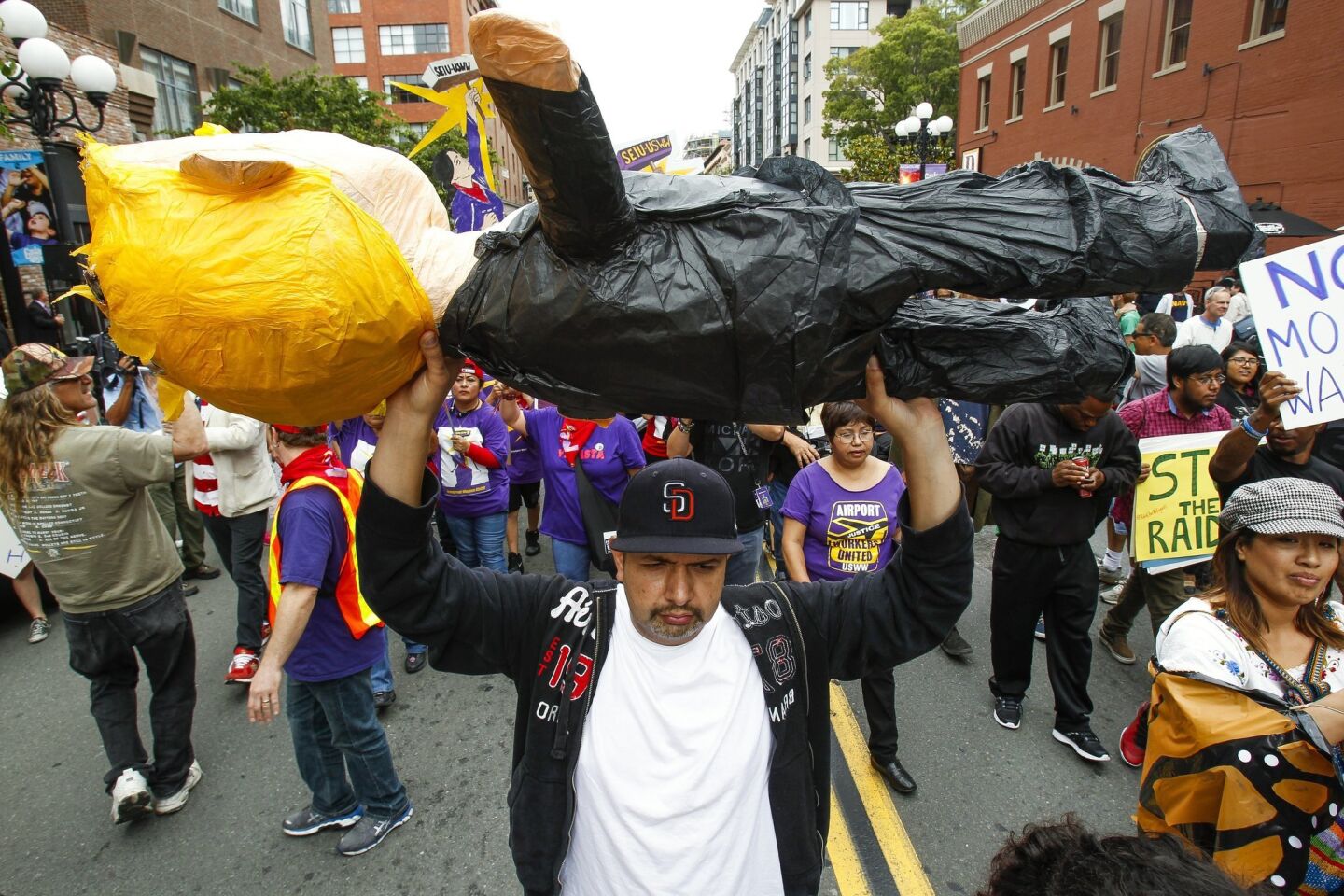 Noel Garcia carries a piñata in the likeness of Donald Trump as he and a group of anti-Trump protesters march down 5th Avenue.