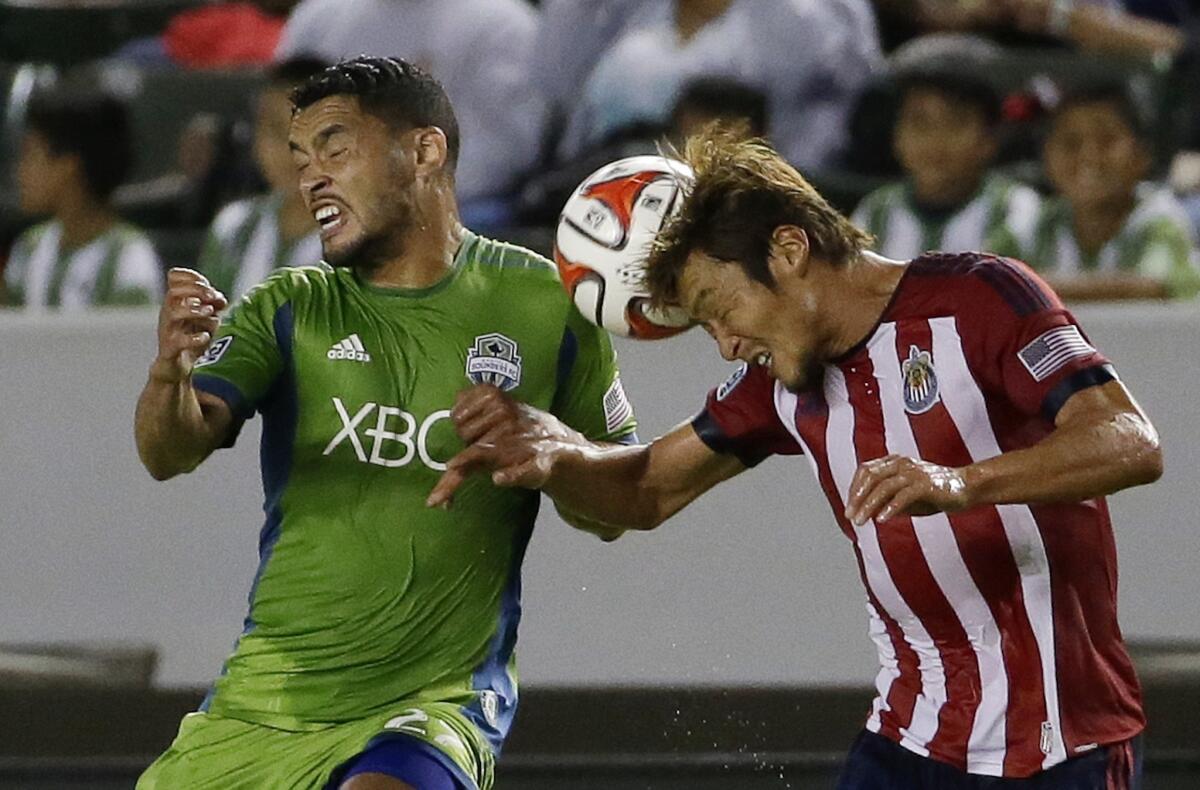 Chivas USA's Akira Kaji, right, heads the ball away from Seattle's Lamar Neagle during the first half of a match on Sept. 3.