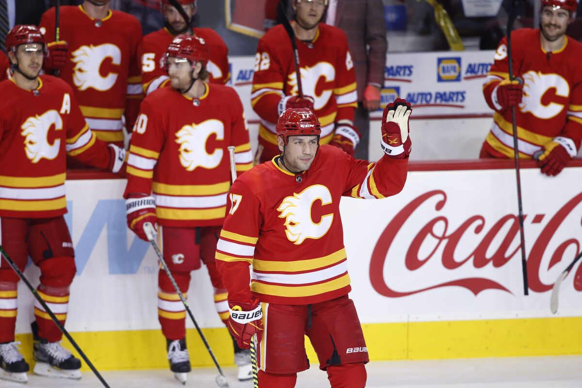 Calgary Flames' Milan Lucic acknowledges the crowd during a celebration of his having played in more than 1,000 games, during the first period of the team's NHL hockey game against the Boston Bruins on Saturday, Dec. 11, 2021, in Calgary, Alberta. (Larry MacDougal/The Canadian Press via AP)