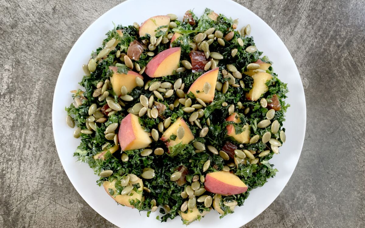 Kale salad with peaches and pepitas.