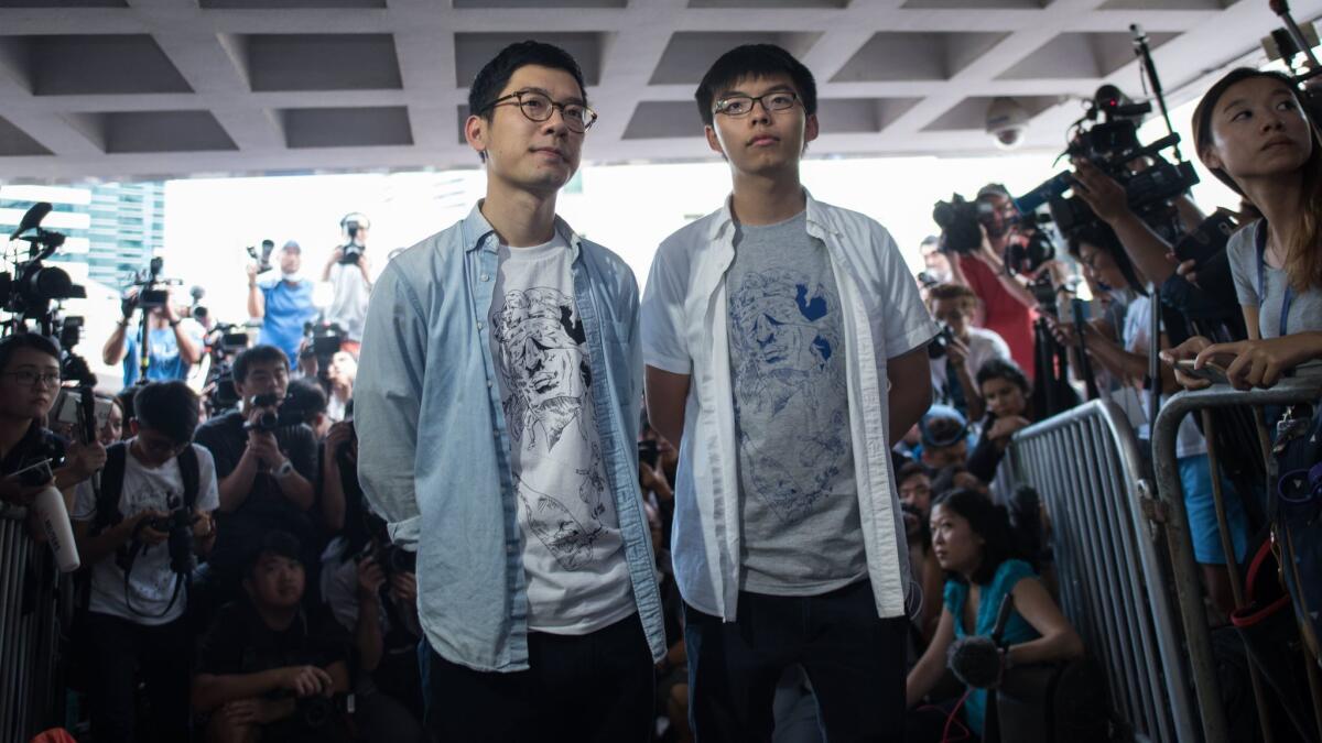 Student pro-democracy activists Nathan Law, left, and Joshua Wong speak to the media outside Hong Kong's High Court on Aug. 17, 2017, on the day of their sentencing for unlawful assembly.