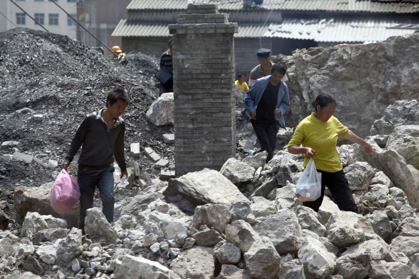 Survivors sift through the remains of a collapsed home in Yiliang in a remote and mountainous area of southwest China. Witnesses said residents ran screaming from their homes and business as two quakes hit on the border of Yunnan and Guizhou provinces an hour apart, followed by a string of aftershocks.